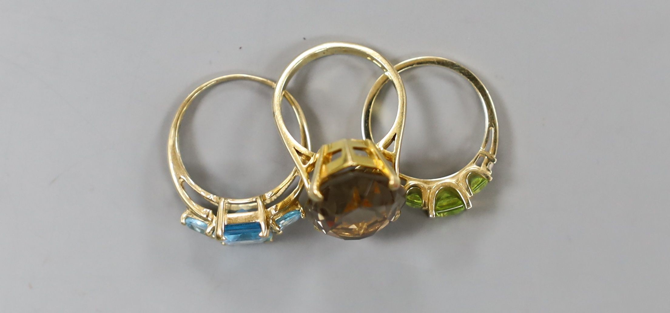 A modern 9ct gold and quartz set dress ring, gross 7.5 grams, a 10k and gem set ring, gross 3 grams and a 14k and gem set ring, gross 3.3 grams.